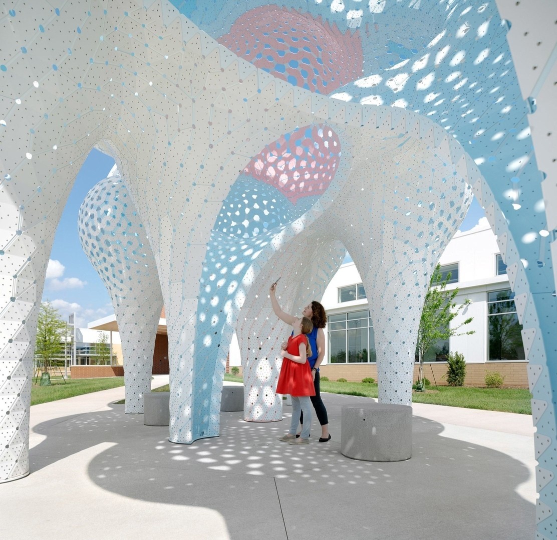 Нью-йоркская студия дизайна The Very Many построила павильон с белыми шарами и лампочками в нежно-голубых, розовых тонах внутри.