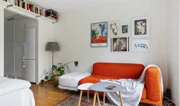 Интерьер скандинавской квартиры-студии 31,4 м2. Прямоугольную комнату зонировали на кухню и гостиную-спальню перегородкой с открытым оконным проемом.