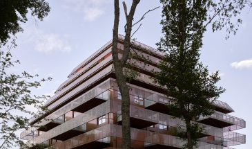 Расположенное на месте бывшего военного лагеря, жилое здание гармонично вписывается в окружающий исторический ландшафт и застройку 1890-х годов, в привлекательной и скромной манере. Благодаря осознанному использованию качественной архитектуры, ориентированной на местоположение, проект подчеркивает и развивает уникальность объекта.