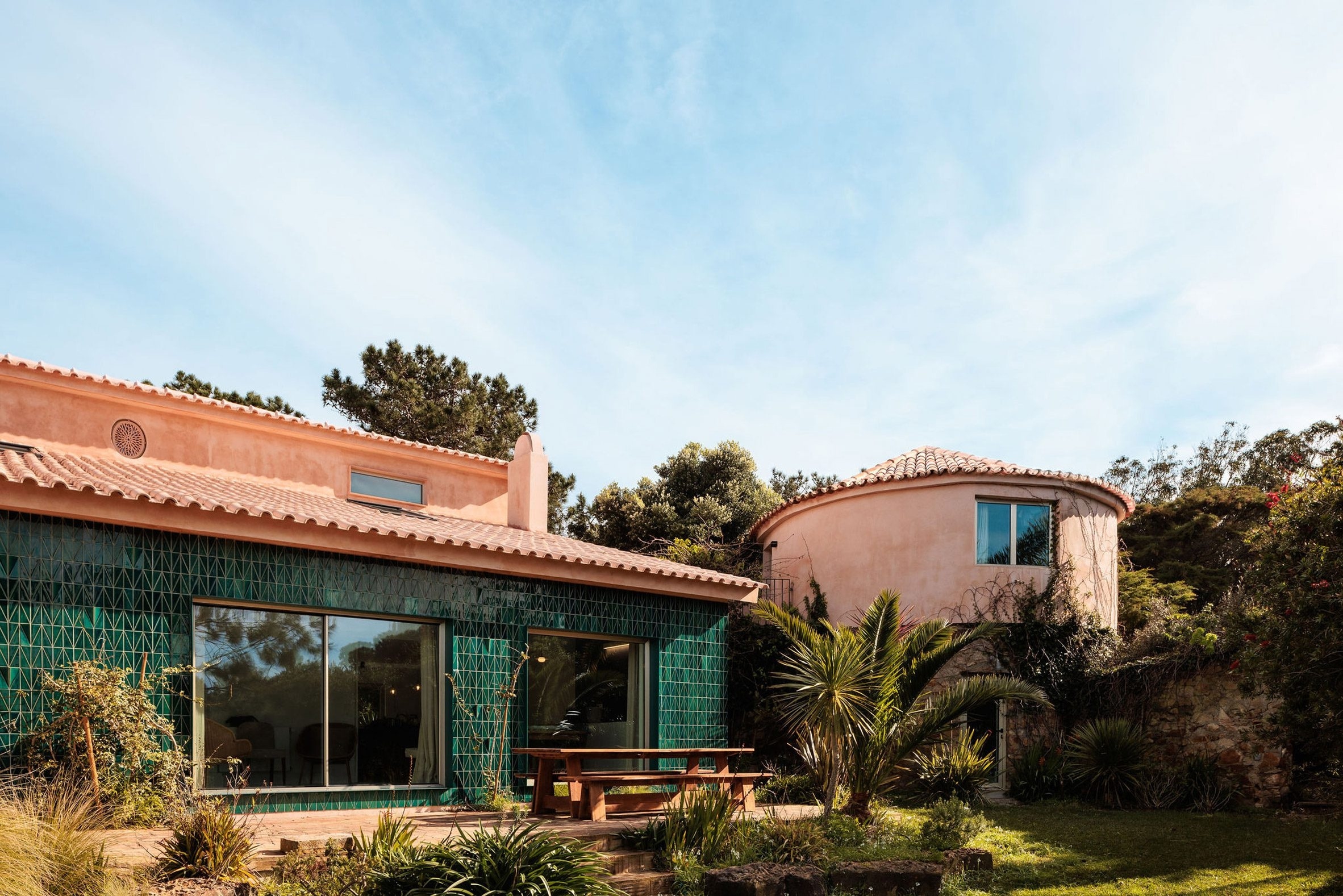 Палитра глянцевой зелёной плитки и штукатурки терракотового оттенка характеризуют гостевой дом AIP House Azóia, созданный португальской студией Joāo Tiago Aguiar Arquitectos.