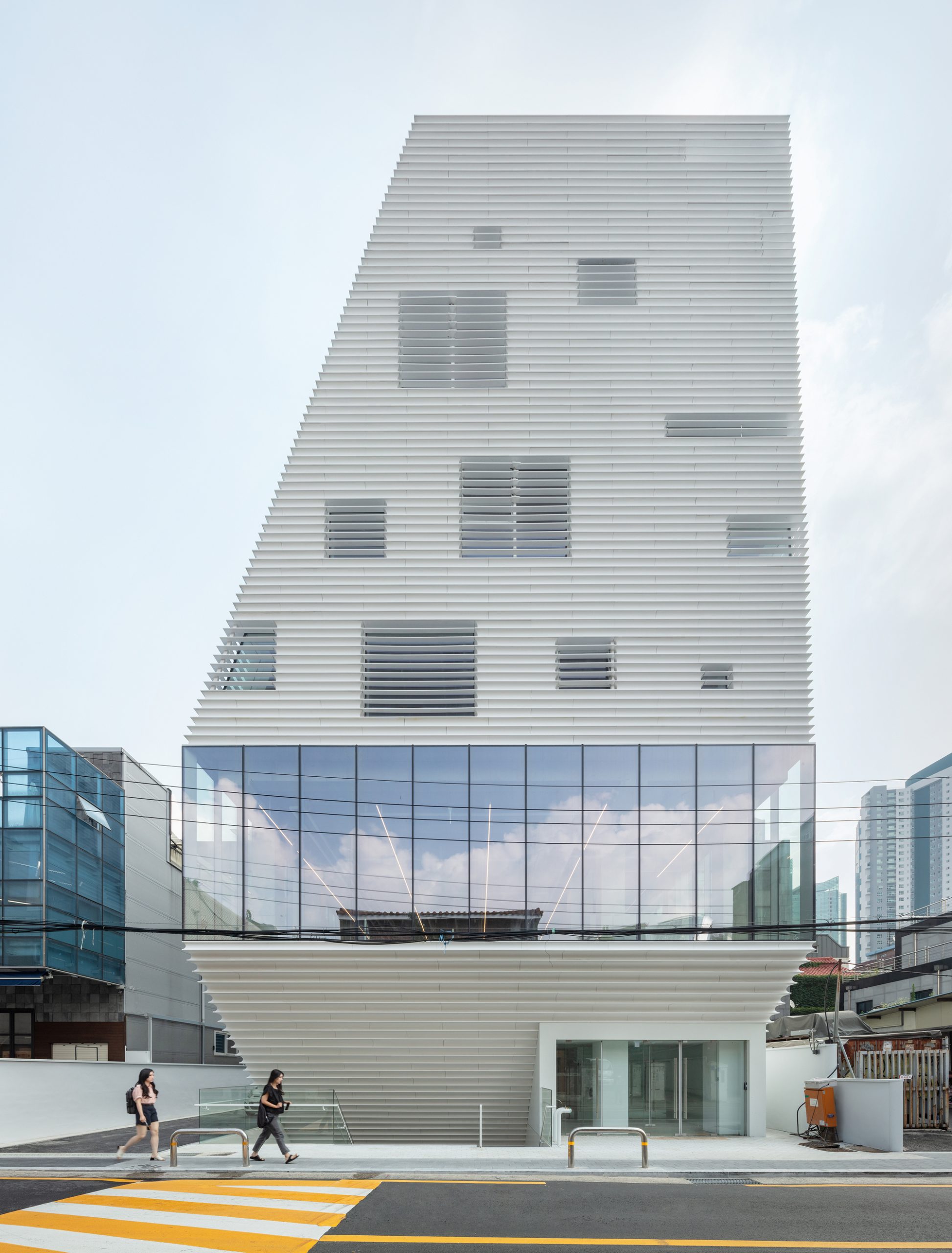 Отступ первого этажа и общественное пространство у входа. Фото: ArchDaily